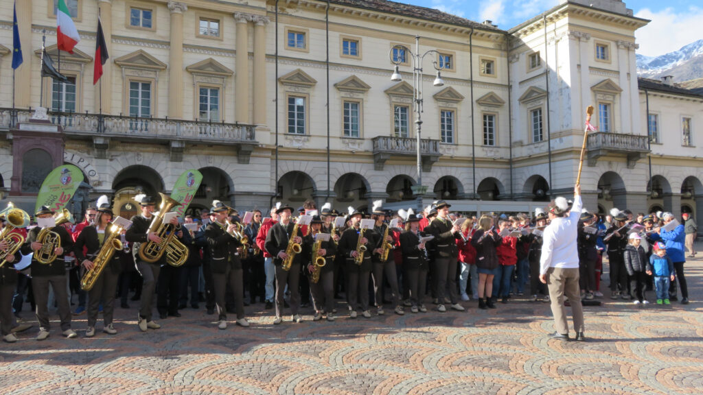 Enrico Montanari dirige, in piazza Chanoux ad Aosta, i 300 musicisti intervenuti per il flash mob