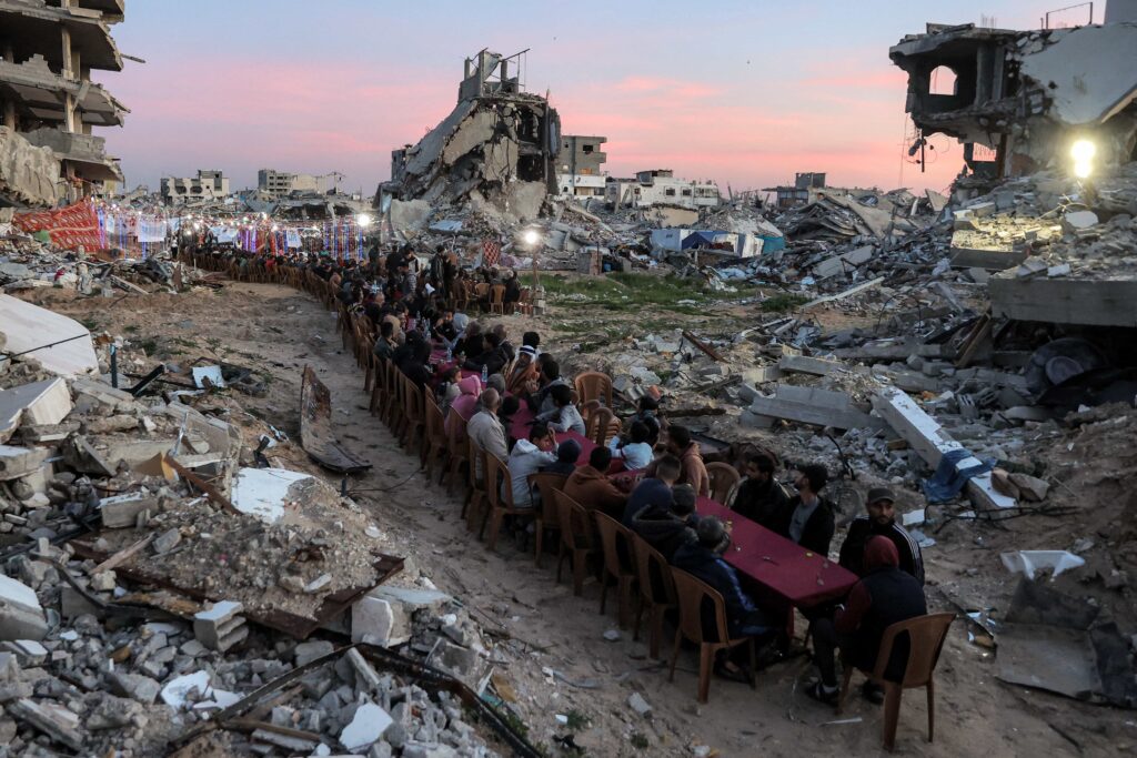 Una lunga tavolata tra le case distrutte di Gaza per la cena dell’ifṭār durante il Ramadan.