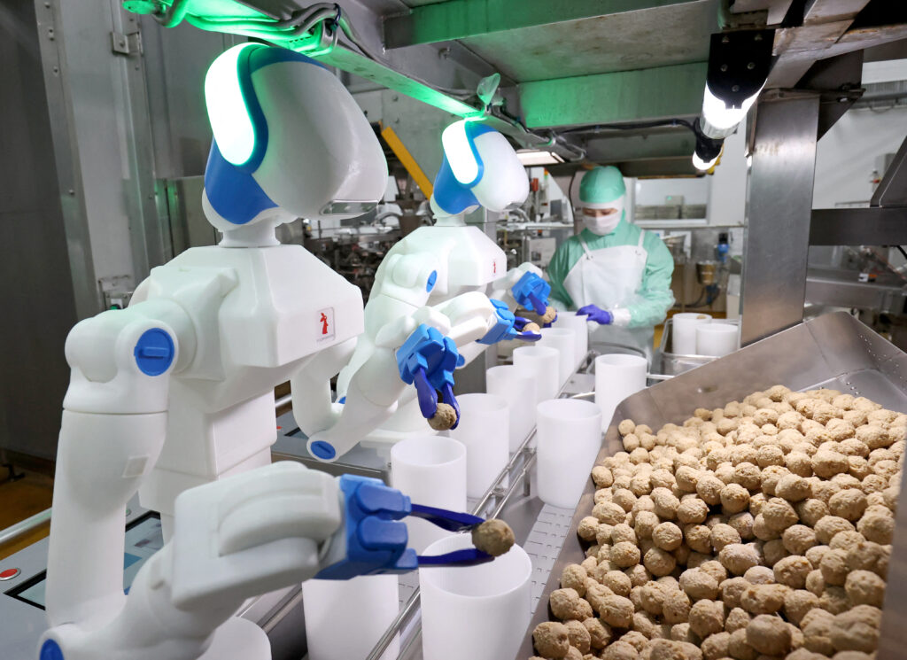 I robot di Foodly, dotati di intelligenza artificiale, affiancano gli operai nella preparazione di polpette di pollo nello stabilimento Ichibiki di Tokai, in Giappone.
